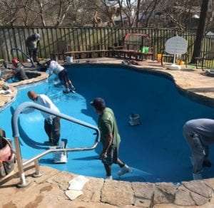 A Crew puts the finishing touches on a blue plaster finish