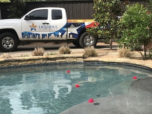 A Liquidus Pool Services truck parked beside a client