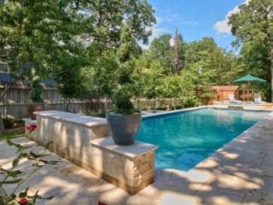 a pool with a stone wall as a water feauture