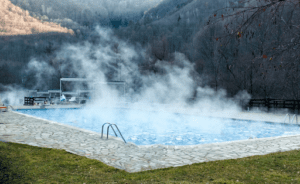 A heated pool with steam coming off the water.