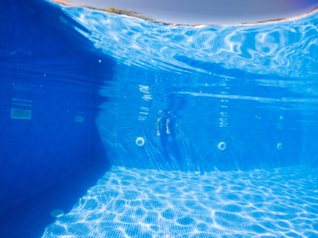 woman relaxing in clear blue swimming pool